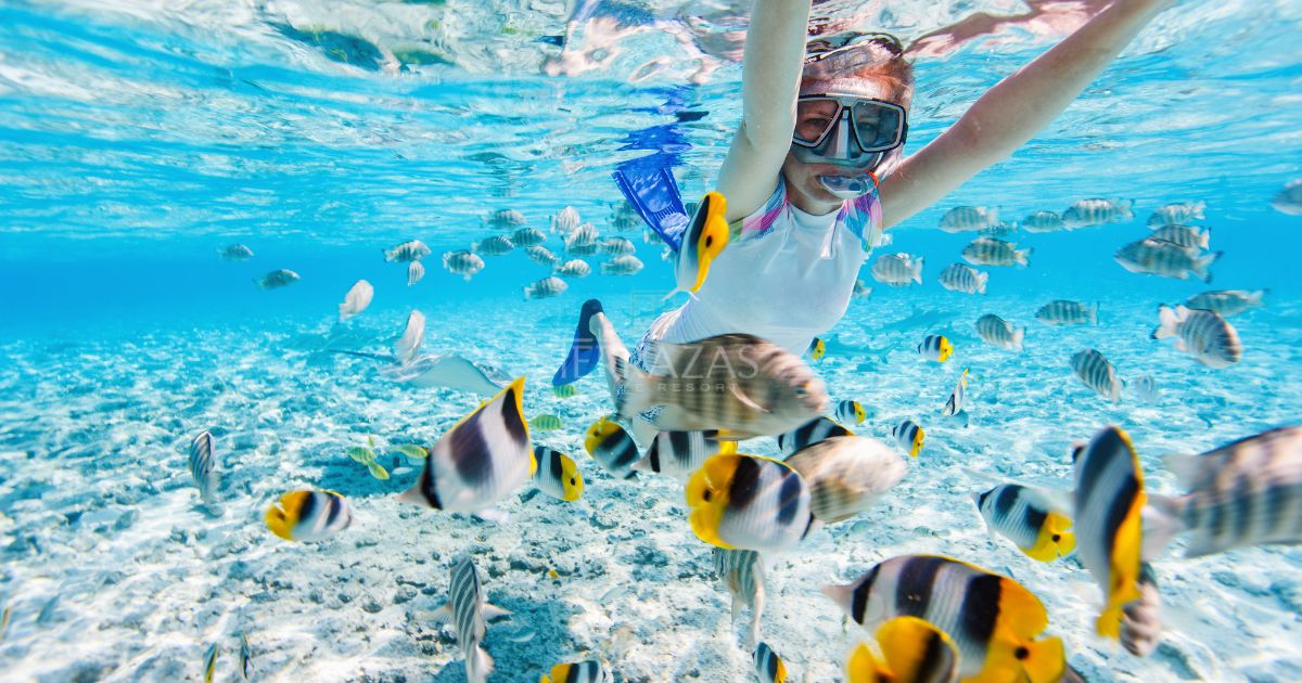 A girl snorkeling with the fish in the waters around Ambergris Caye